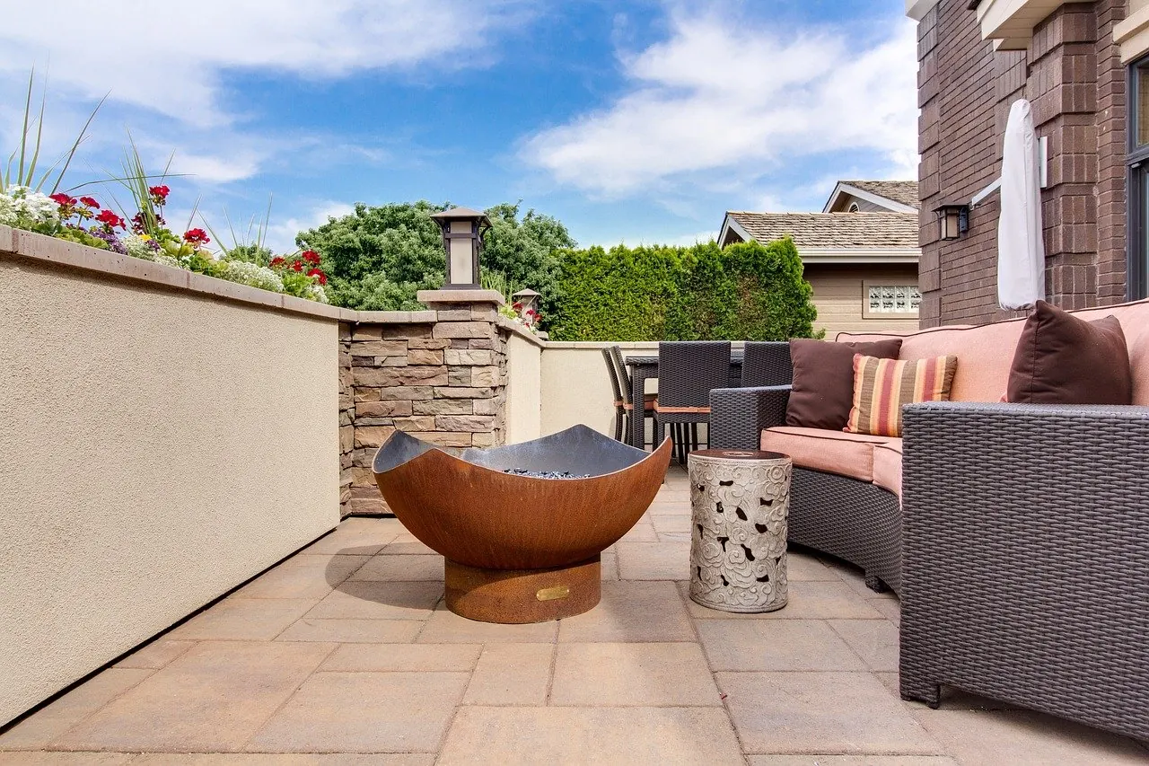 Stucco courtyard concrete patio with seating and a fire bowl in Little Elm, TX