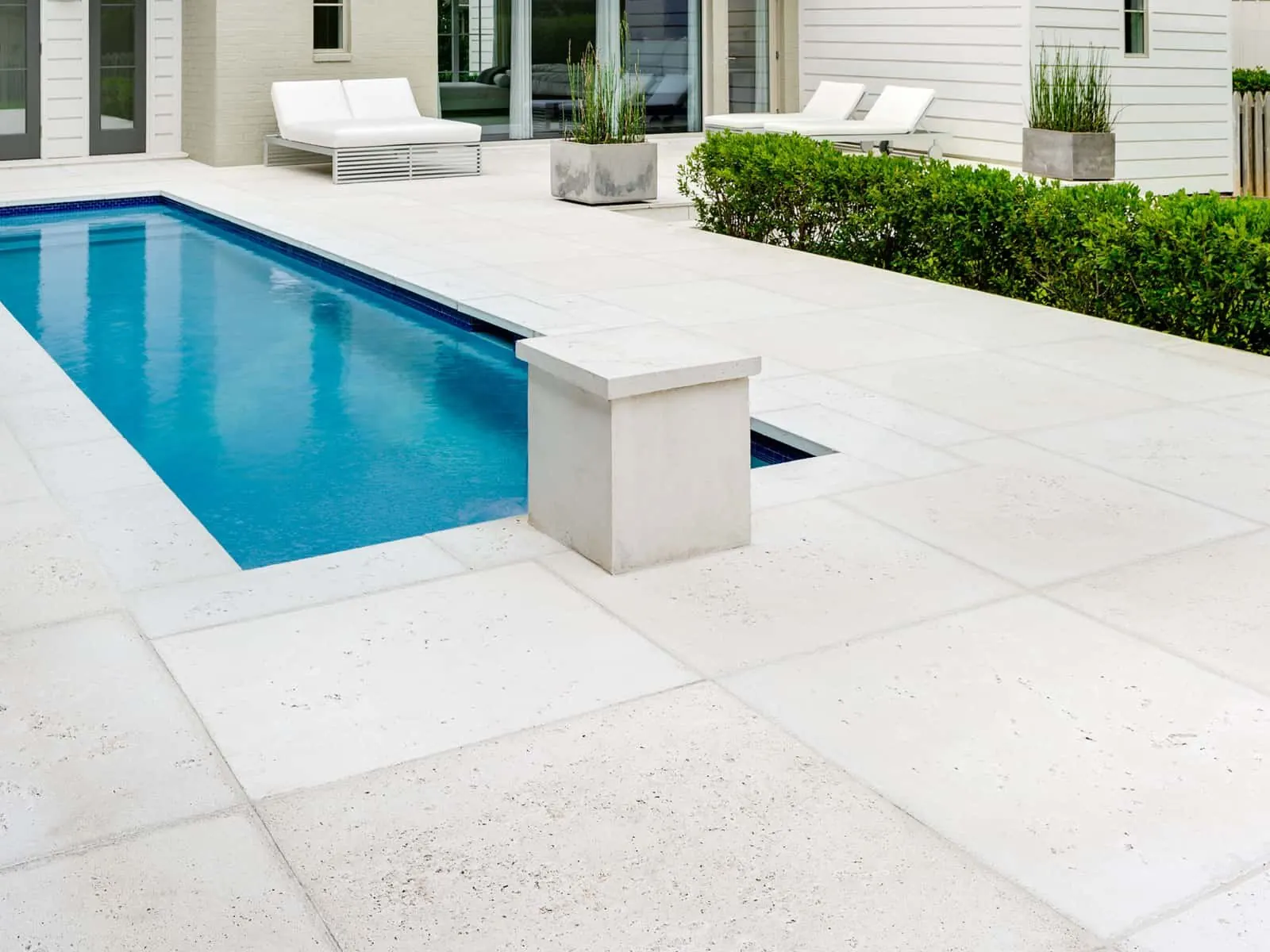 Light concrete pool deck with lounge chairs at a Little Elm, TX home