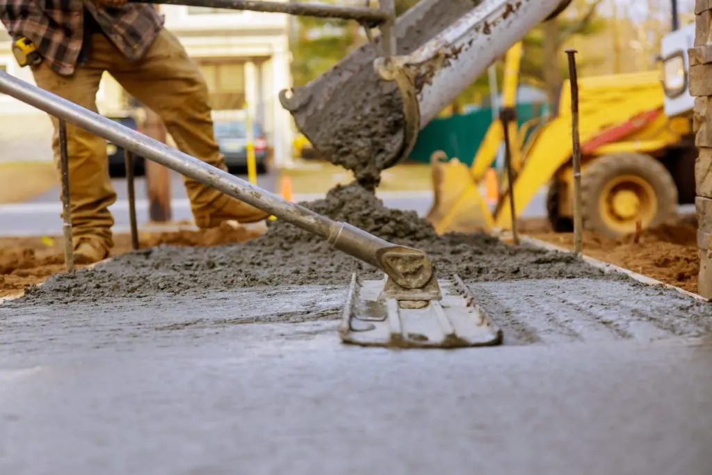 Chute pouring concrete onto a gravel base in Little Elm, TX