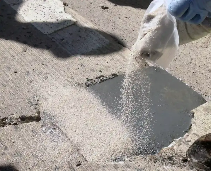 Patching compound being poured into a damaged concrete slab during a repair in Little Elm, TX
