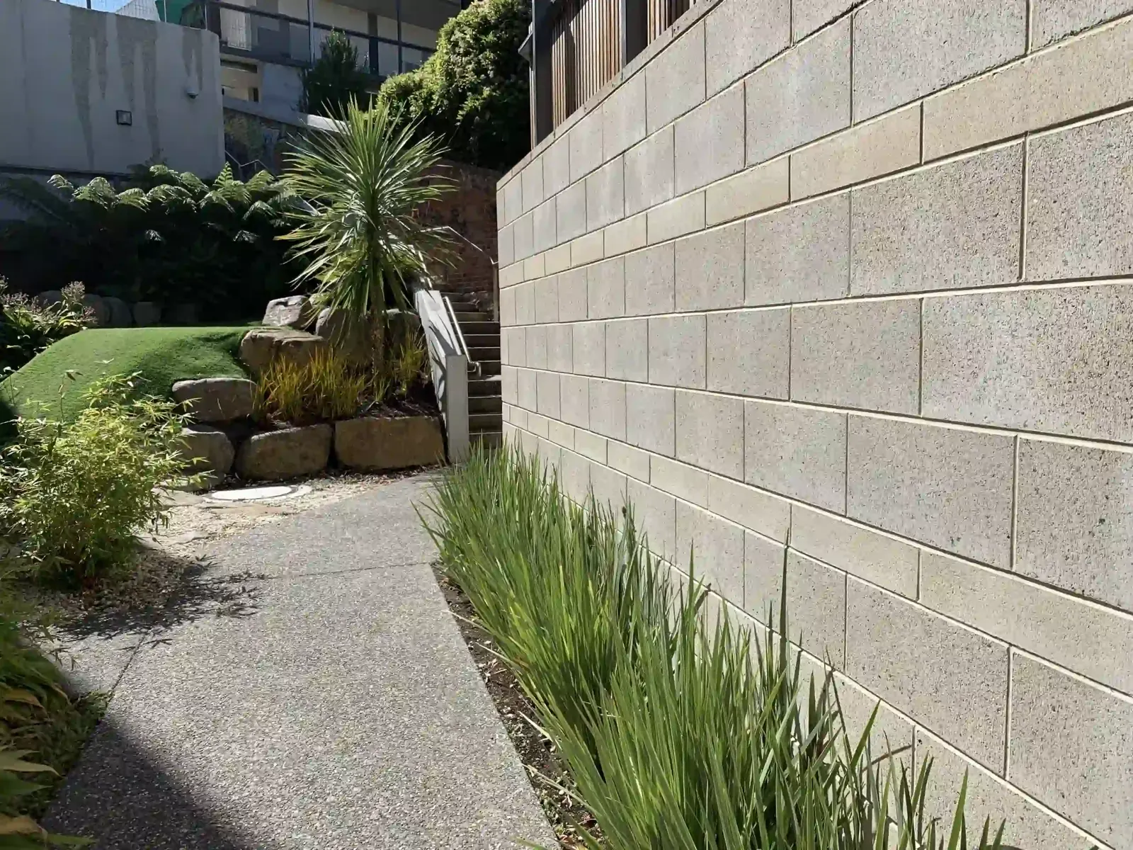 Tall block retaining wall with a planting bed above it at a home in Little Elm, TX