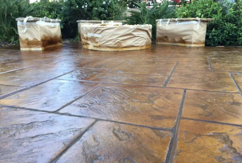 Stained and sealed stamped concrete slab with a glossy tan finish in Little Elm, TX