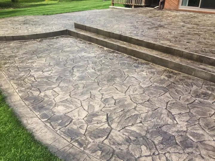 Stamped flagstone-pattern concrete with a matching step at a home in Little Elm, TX